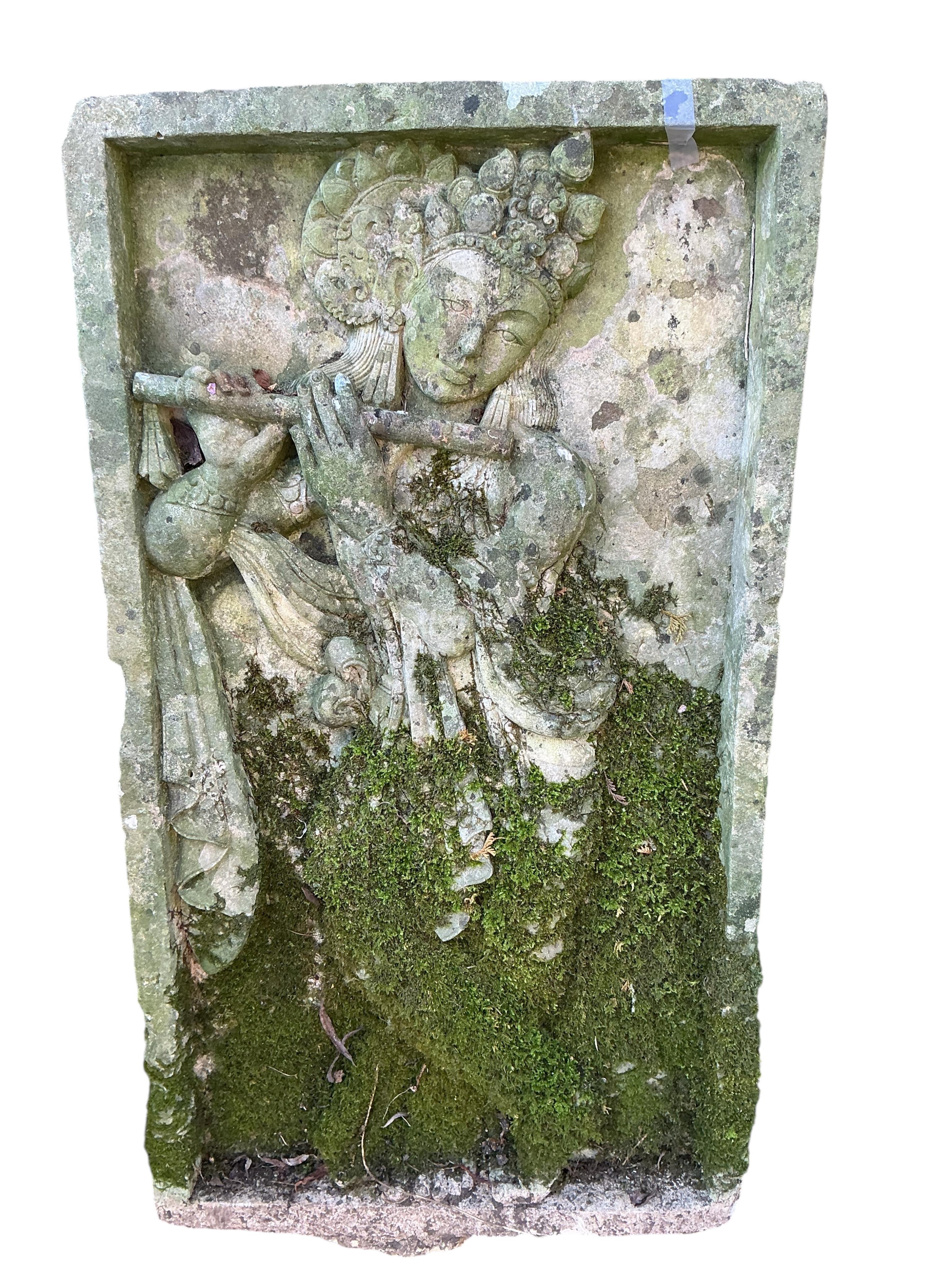 A reconstituted stone relief panel of Krishna playing the flute, width 50cm, height 90cm